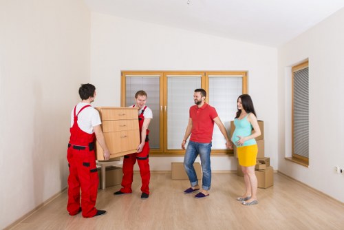 Movers carrying furniture through a local North Sheen street